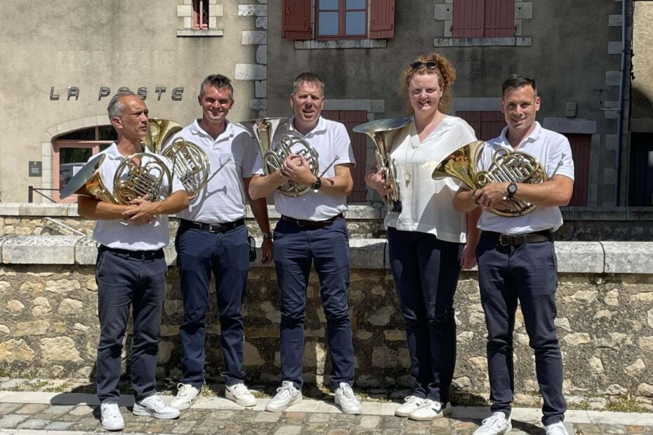 5 Hoornisten van het klassiek hoornensemble the horn revival poseren voor een foto met hun franse hoorn vast.